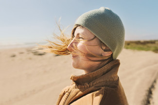 Frau am Strand - Wind von hinten