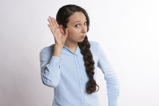 Frau mit Hand am Ohr