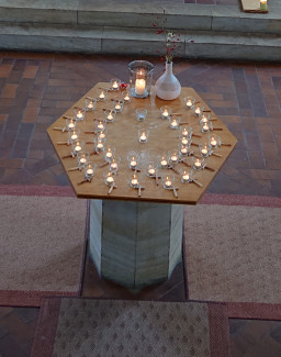 Taufstein mit Kerzen und Kreuzen