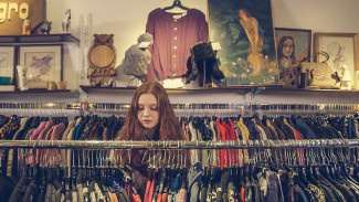 Junge Frau sucht im Laden Kleider aus