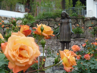 Skulptur von Anne Frank mit Rosen